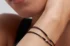 two diamond string bracelets on a wrist